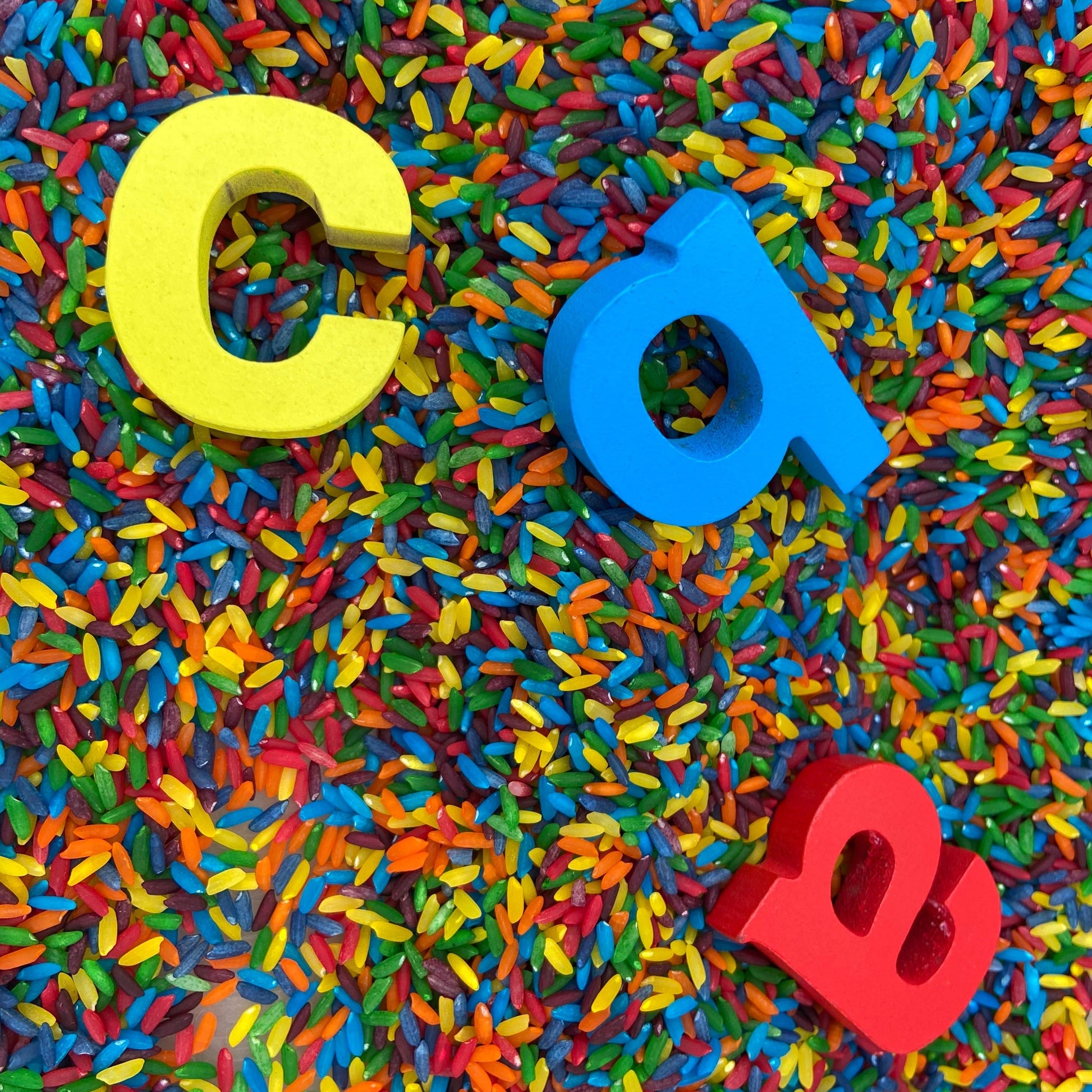 Wooden rainbow artifact with colorful rice, showcasing a DIY rainbow-making activity using non-toxic sensory materials and sensory bin fillers.