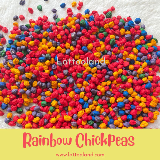 Brightly colored chickpeas in a variety of vibrant shades, such as red, blue, yellow, and green, spread out in a sensory play bin. The smooth, round textures of the chickpeas invite touch and exploration, creating an engaging, hands-on activity for children.