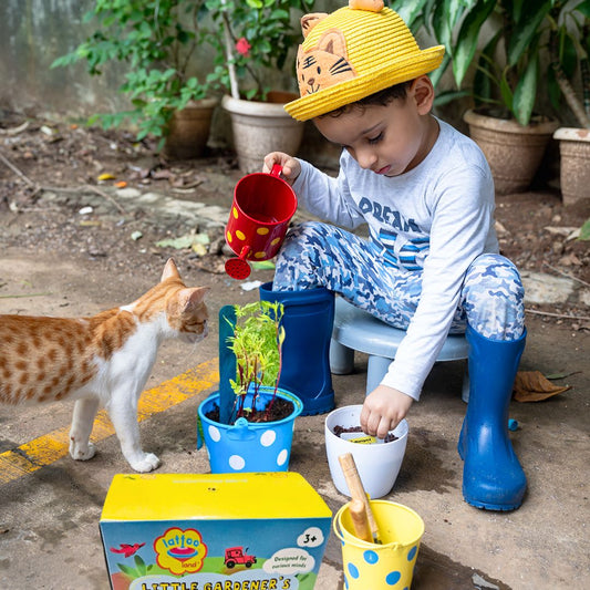 Interactive gardening kit for kids with trowel, fork, metal planters, and watering can.